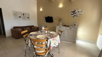 a living room with a table with chairs and a couch at Petite maison à 2 pas du centre de Bédoin in Bédoin