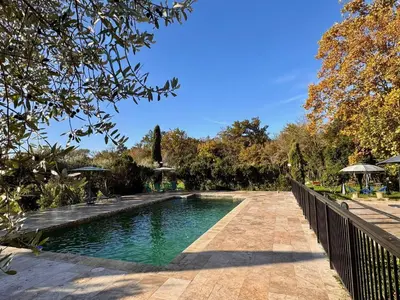 a swimming pool in a garden with a fence at Mas d Anissa in Avignon