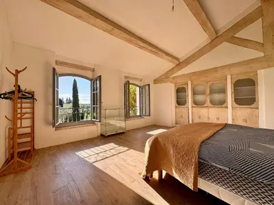 a bedroom with a bed and a large window at Mas d Anissa in Avignon