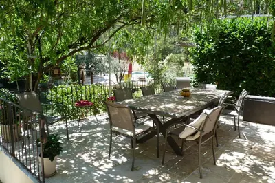 a table and chairs sitting under a tree at Villa Au Coeur Du Luberon in Maubec