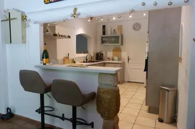 a kitchen with a counter and two bar stools at Villa Au Coeur Du Luberon in Maubec