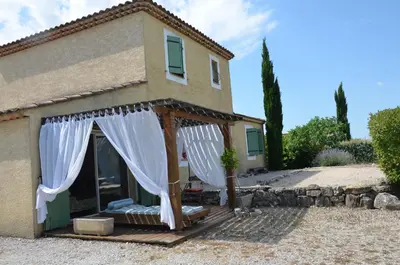 a house with a porch with white curtains on it at Villa provençale piscine, calme et confort in Saint-Cannat