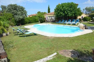 a swimming pool with lounge chairs and a house at Villa provençale piscine, calme et confort in Saint-Cannat