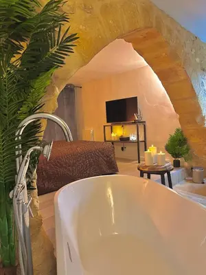 a bathroom with a sink and a living room at Luxe & Volupté sous les Voûtes d'Aix centre ville in Aix-en-Provence