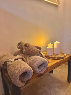 a wooden table with two candles and towels on it at Luxe & Volupté sous les Voûtes d'Aix centre ville in Aix-en-Provence