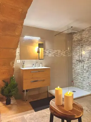 a bathroom with a sink and a shower with two candles at Luxe & Volupté sous les Voûtes d'Aix centre ville in Aix-en-Provence