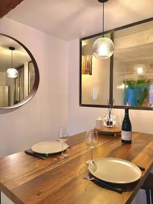 a dining room table with two white plates and wine glasses at Luxe & Volupté sous les Voûtes d'Aix centre ville in Aix-en-Provence