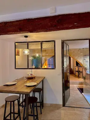 a dining room with a wooden table and chairs at Luxe & Volupté sous les Voûtes d'Aix centre ville in Aix-en-Provence