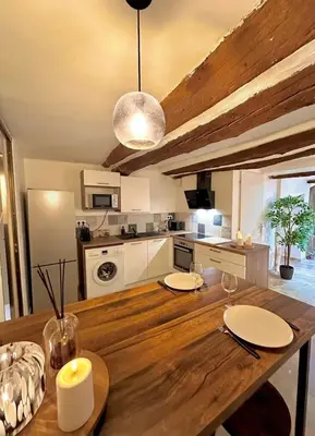 a kitchen with a wooden table and a dining room at Luxe & Volupté sous les Voûtes d'Aix centre ville in Aix-en-Provence