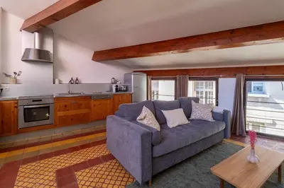 a living room with a blue couch and a kitchen at Duplex avec terrasse, au cœur d'Aix-en-Provence in Aix-en-Provence