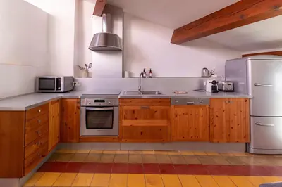a kitchen with wooden cabinets and a stainless steel refrigerator at Duplex avec terrasse, au cœur d'Aix-en-Provence in Aix-en-Provence