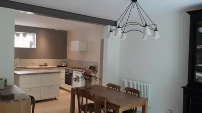 a kitchen with a wooden table and a dining room at Fully renovated Provençal farmhouse in Châteauneuf-de-Gadagne
