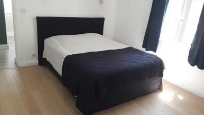 a bed in a room with a black and white bedvisor at Fully renovated Provençal farmhouse in Châteauneuf-de-Gadagne