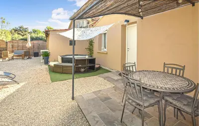 a patio with a table and chairs and a grill at Maisonnette Avec Jacuzzi in Mazan