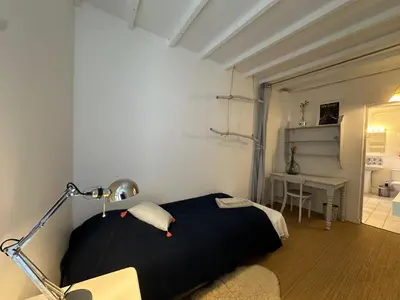 a bedroom with a black bed and a desk at Maison des Fontaines - Terrasse & vue sur vignoble, proche Aix-en-Provence 5 personnes - Domaine Viticole Château de Barbebelle, Rognes, Provence in Rognes