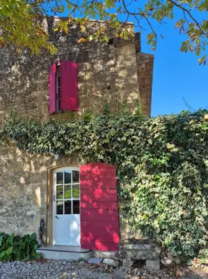 a building with a red door and ivy at Maison des Fontaines - Terrasse & vue sur vignoble, proche Aix-en-Provence 5 personnes - Domaine Viticole Château de Barbebelle, Rognes, Provence in Rognes