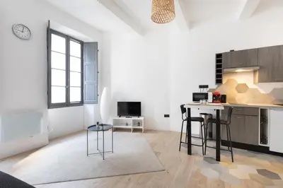 a kitchen and living room with a table and chairs at Le Rimbaud - Studio moderne en hypercentre - WiFi in Carpentras
