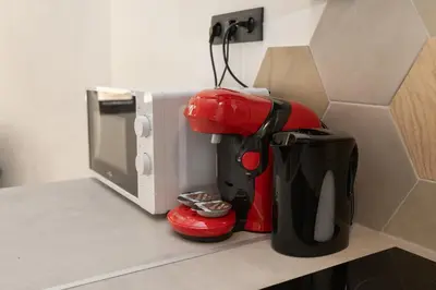 a kitchen counter with a coffee maker next to a microwave at Le Rimbaud - Studio moderne en hypercentre - WiFi in Carpentras