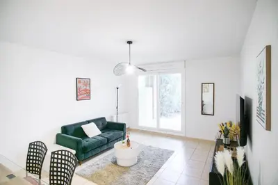 a living room with a green couch and chairs at T2 cosy avec jardin & parking gratuit - Quartier Beauregard in Aix-en-Provence