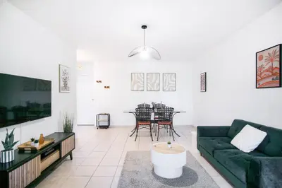 a living room with a green couch and a table at T2 cosy avec jardin & parking gratuit - Quartier Beauregard in Aix-en-Provence