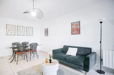 a living room with a green couch and a table at T2 cosy avec jardin & parking gratuit - Quartier Beauregard in Aix-en-Provence