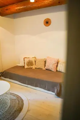 a bed in the corner of a room with pillows at Charming House At The Foot Of Luberon In Maubec in Maubec