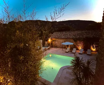 a swimming pool in front of a building with a house at Charming House At The Foot Of Luberon In Maubec in Maubec