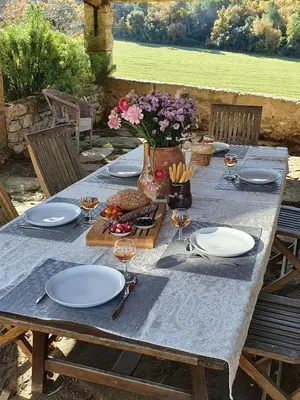 a table with plates and wine glasses and flowers on it at Historic Mansion In Provence Vineyards in La Tour-dʼAigues
