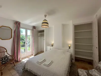 a bedroom with a large bed and a window at Villa des Platanes - Maison provençale avec jardin, parking & barbecue au cœur du vignoble du Château de Barbebelle Rognes - Proche Aix-en-Provence - 6 personnes in Rognes