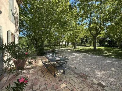 a patio with a table with wine glasses on it at Villa des Platanes - Maison provençale avec jardin, parking & barbecue au cœur du vignoble du Château de Barbebelle Rognes - Proche Aix-en-Provence - 6 personnes in Rognes