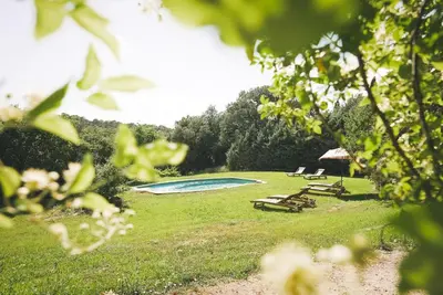 a group of chairs and a swimming pool in a field at Villa du Puits - Séjour en Provence avec piscine privée & jardin au cœur d'un domaine viticole Château de Barbebelle - Rognes - Proche d'Aix-en-Provence -10 personnes in Rognes