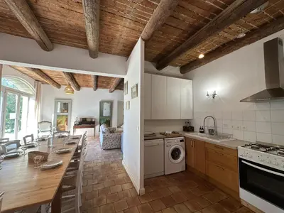 a kitchen with white cabinets and a table with a sink at Villa du Puits - Séjour en Provence avec piscine privée & jardin au cœur d'un domaine viticole Château de Barbebelle - Rognes - Proche d'Aix-en-Provence -10 personnes in Rognes