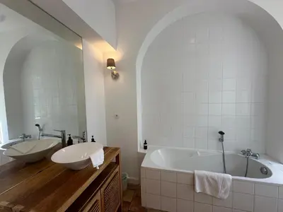 a bathroom with two sinks and a bath tub at Villa du Puits - Séjour en Provence avec piscine privée & jardin au cœur d'un domaine viticole Château de Barbebelle - Rognes - Proche d'Aix-en-Provence -10 personnes in Rognes