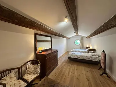 a bedroom with two beds and a mirror and a chair at Villa du Puits - Séjour en Provence avec piscine privée & jardin au cœur d'un domaine viticole Château de Barbebelle - Rognes - Proche d'Aix-en-Provence -10 personnes in Rognes