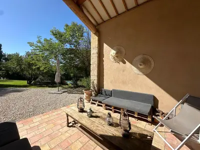 a couch and a chair on a patio at Villa du Puits - Séjour en Provence avec piscine privée & jardin au cœur d'un domaine viticole Château de Barbebelle - Rognes - Proche d'Aix-en-Provence -10 personnes in Rognes