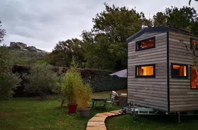 a tiny house in a yard with a table at Tiny House avec vue sur le rocher de Saignon, Luberon in Saignon