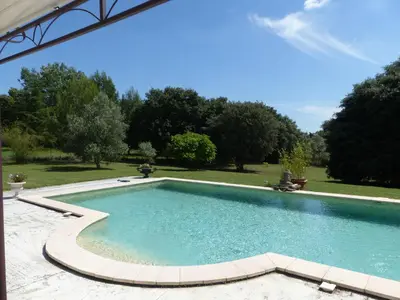 a swimming pool in a yard with trees at Les Anges in LʼIsle-sur-la-Sorgue