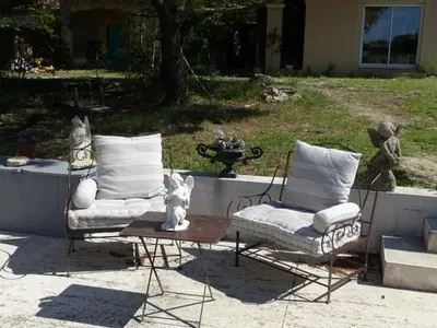 two chairs sitting on a table in a yard at Les Anges in LʼIsle-sur-la-Sorgue