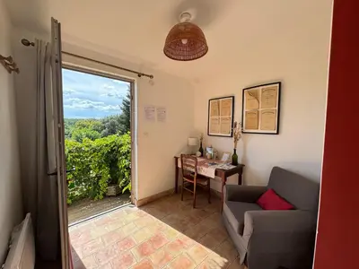 a living room with a couch and a table and a window at Studio Ouest - Chambre avec vue vignoble - Domaine viticole Château Barbebelle Rognes - Proche d'Aix-en-Provence in Rognes