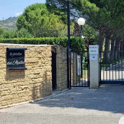 a patio with two chairs and an umbrella at L'Etreinte Bleue de Provence in Eyguières