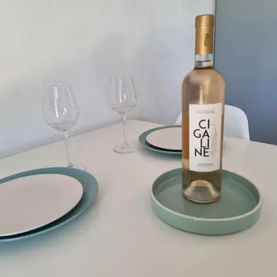 a white table with a bottle of wine on it at L'Etreinte Bleue de Provence in Eyguières
