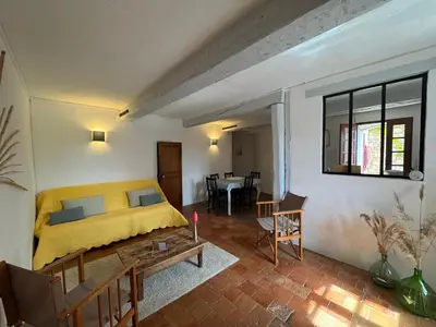 a bedroom with a yellow bed and a living room at Maison du Berger - Vignoble Château Barbebelle, Rognes, maison provençale avec jardin partagé et parking - proche d'Aix-en-Provence - 5 personnes in Rognes