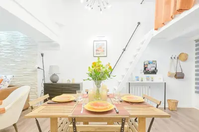 a dining room with a wooden table and chairs at Evasion au centre d Aix loft chic et cosy in Aix-en-Provence