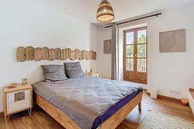 a bedroom with a large bed and a large window at La Cour de Pétrarque in Fontaine-de-Vaucluse