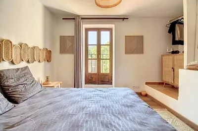 a bedroom with a large bed and a window at La Cour de Pétrarque in Fontaine-de-Vaucluse