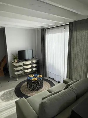 a living room with a couch and a table at Tiny house avec terrasse privée - Parking - Fibre TV in Lambesc