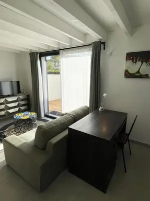 a living room with a couch and a large window at Tiny house avec terrasse privée - Parking - Fibre TV in Lambesc