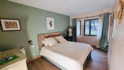 a bedroom with a white bed with two windows at Appartement golf saumane Celomidie in Saumane-de-Vaucluse