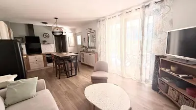 a kitchen and living room with a table and a refrigerator at Appartement golf saumane Celomidie in Saumane-de-Vaucluse