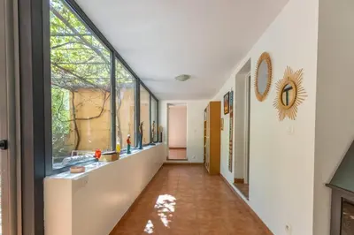a hallway with large windows and a long hallway with a hallway at Villa sur Domaine Aix - Piscine & Tennis - Wagner in Aix-en-Provence